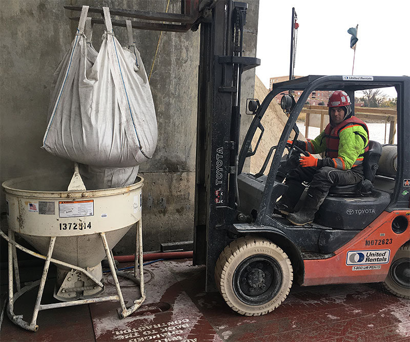 Loading concrete bucket with grout and 10mm pea gravel to continuously feed the pump.