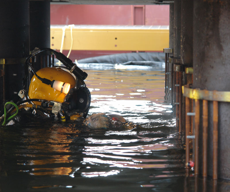 Installing threaded shear studs above and below water level along with reinforcing cage around the pile